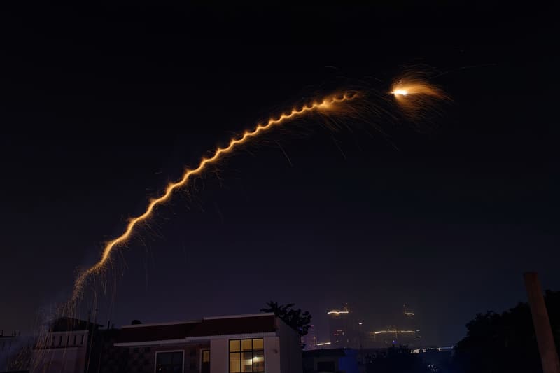 A rocket climbing into the night sky leaving a golden trail