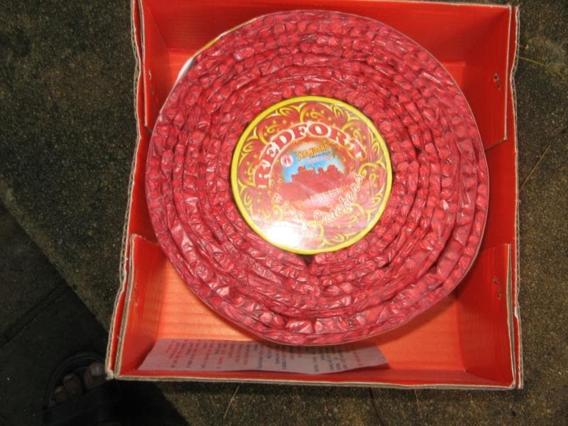 A coiled 1000 wala string cracker in its box