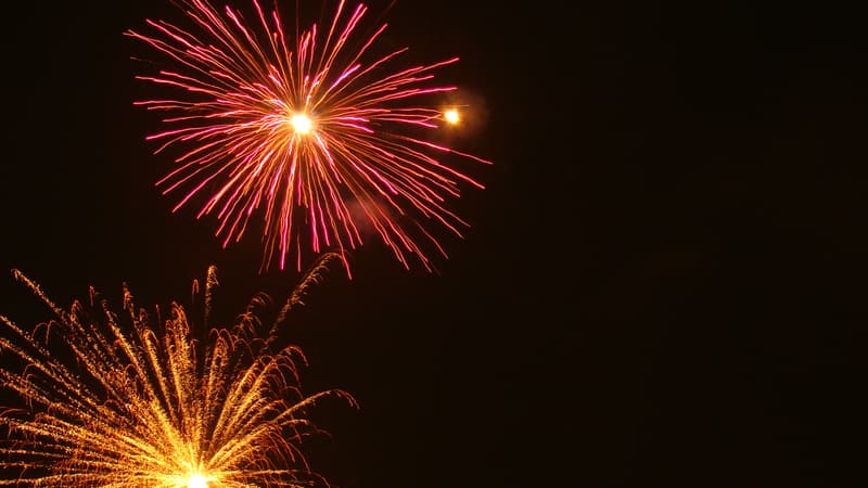 Red and gold fireworks bursting over a festival ground